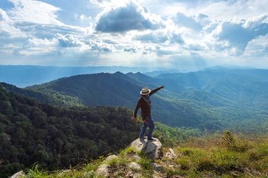 İnsan silueti dağın zirvesinde el ele tutuşur, başarı kavramı.