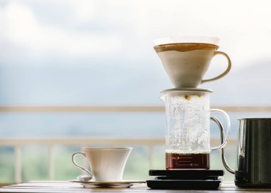Kağıt filtreye bir fincan taze sıcak kahve damlatıyor.