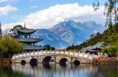 Yeşim Ejder Kar Dağı ve Suocui Köprüsü 'nün güzel manzarası Jade Spring Park' taki Kara Ejder Havuzu üzerinde, Lijiang, Yunnan