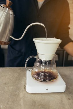 Barista kahve yapıyor, metot dökülüyor, kahve damlıyor.