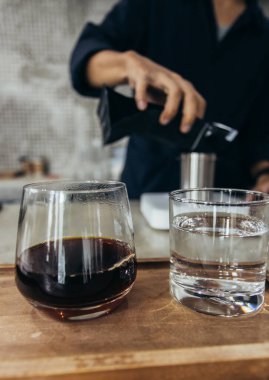 Barista kahve yapıyor, metot dökülüyor, kahve damlıyor.