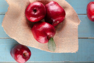 Masada yaprakları olan kırmızı elmalar.