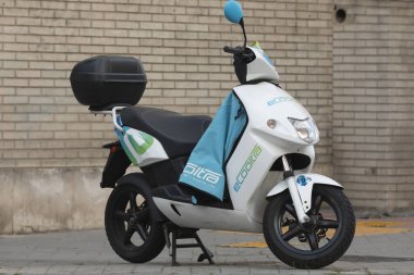 Madrid, Spain - May 19, 2020: Electric motorcycle of the shared system transport service from the eCooltra company, parked in O'donell street. clipart