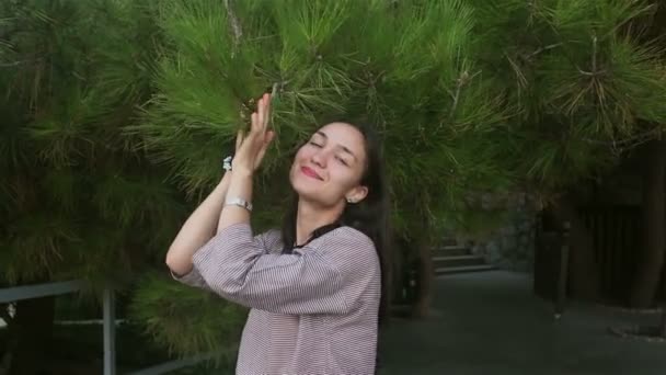 Закрывая Портрет Молодой Привлекательной Девушки Наклоняет Ветку Хвойного Дерева Наслаждаясь — стоковое видео