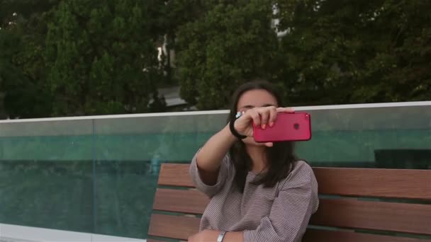 Młoda Piękna Dziewczyna Robi Sobie Selfie Swoim Smartfonie Siedząc Ławce — Wideo stockowe