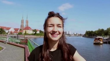 Genç ve güzel bir kızın portresi. Kız kameraya bakar ve gülümser..