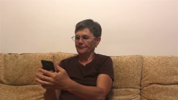 Evde Bir Kanepede Otururken Akıllı Telefondan Haber Okuyan Çekici Yetişkin — Stok video
