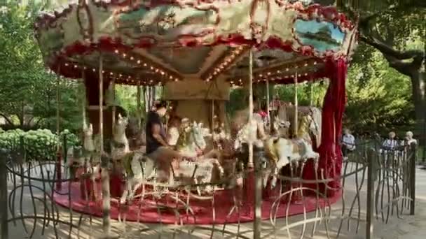 ポーランドのWroclaw June 242019 子供を持つ両親は公園の古いカルーセルに乗っています 幸せな子供たちと両親は夏の日にカルーセルに乗る — ストック動画
