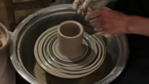 主人准备用粘土作工 大师的手用陶工的轮作了一个粘土制品的雕塑品 那个陶工教他的徒弟掌握技巧 主人创造了一个白土产品 — 图库视频影像