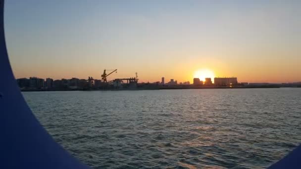 海洋和海港的日落 从邮轮的客舱欣赏海洋和城市 透过船的港口欣赏日落和海洋 — 图库视频影像