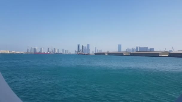在阳光明媚的日子里 可以欣赏到海港和蓝色海洋的景色 透过邮轮的港口 欣赏蓝色海洋 海港和城市景观与摩天大楼在地平线上 — 图库视频影像