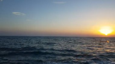 Okyanus ve günbatımı manzarası. Mavi okyanus dalgalarının üzerinde gün batımı. Mavi okyanus ve ufukta gün batımı.