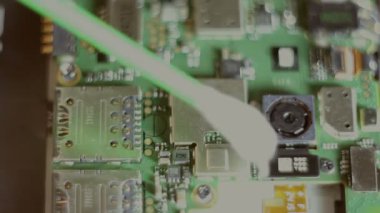 Usta, akıllı telefon çipinin tozunu siler. Close.