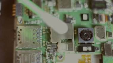 Usta, akıllı telefon çipinin tozunu siler. Close.