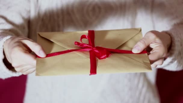 Mooie Meisje Handen Houden Een Cadeau Envelop Met Een Rood — Stockvideo