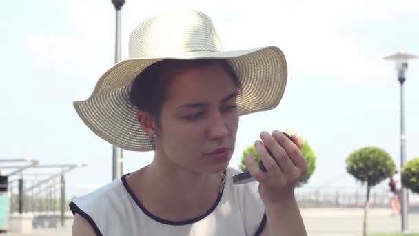 Seorang Gadis Muda Yang Cantik Dengan Topi Putih Mengecat Bibirnya — Stok Video