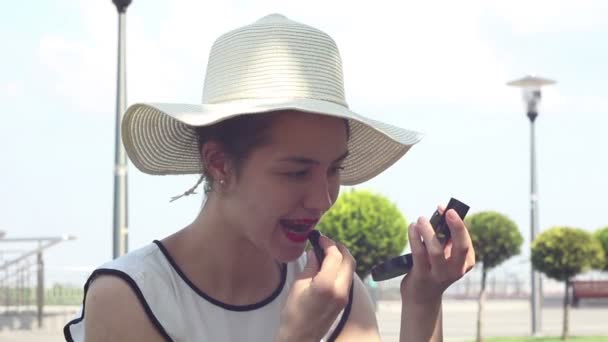 Beautiful Young Girl White Hat Paints Her Lips Red Lipstick — Stock Video