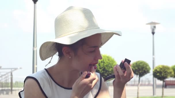 Ein Schönes Junges Mädchen Mit Weißem Hut Bemalt Ihre Lippen — Stockvideo