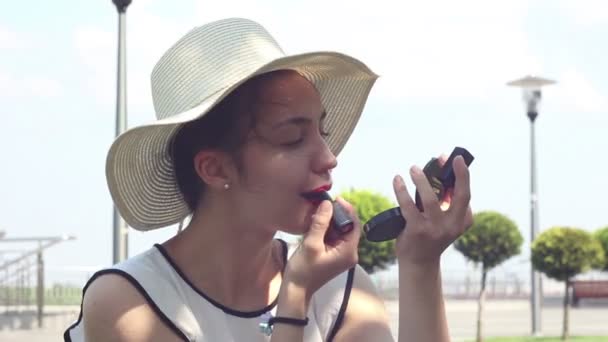 Beautiful Young Girl White Hat Paints Her Lips Red Lipstick — Stock Video