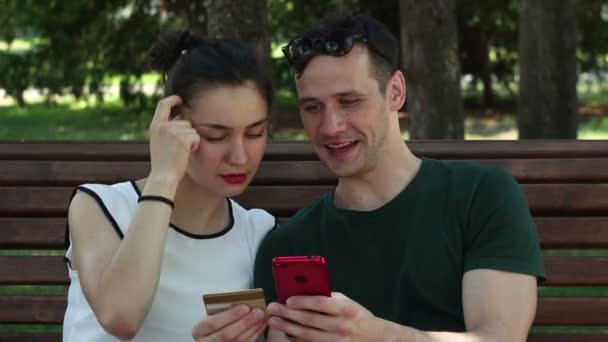 Ett Ungt Förälskat Par Anger Kreditkortsuppgifter Smartphone För Att Betala — Stockvideo