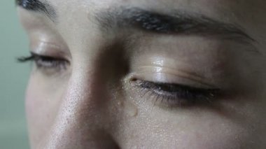 Güzel genç kız üzgün ve ağlıyor. Yanaktaki yeşil gözlerden yaş lar akıyor. Gözler kapanıyor. Genç güzel bir kızın portresi.