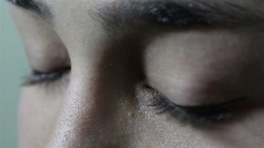 Güzel genç bir kız kameraya bakarak büyük yeşil-kahverengi gözlerini açar. Yanıp sönüyor.