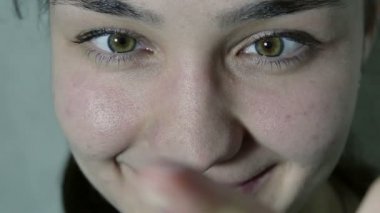 Güzel bir genç kız onu takmadan önce kontakt lense bakar. Genç ve güzel bir kızın portresi.