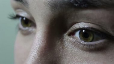 Büyük yeşil-kahverengi gözleri ile güzel bir genç kız kameraya coquettishly görünüyor. Yanıp sönme yakın.