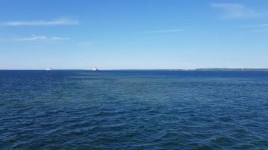 Okyanus manzarası ve gökyüzündeki bulutlar. Okyanus üzerinde güneşli havada bulutlu mavi gökyüzü. Ufuktaki dağlar ve okyanus.