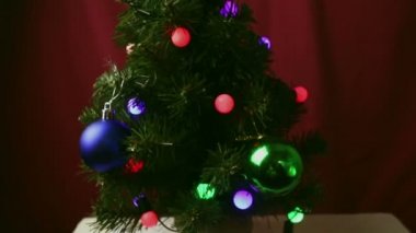 Renkli ışıkları, oyuncakları ve hediyeleri olan Noel ağaçları. Güzel ambalajlı yeni yıl hediyeleri oyuncaklar ve çelenklerle süslenmiş bir Noel ağacının altında yatıyor..
