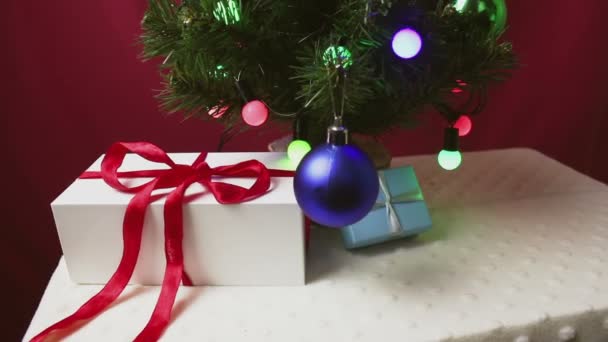 美しい贈り物は装飾されたクリスマスツリーの下にあります — ストック動画