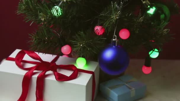 カラフルなライト おもちゃ 贈り物を持つクリスマスツリー 美しい包装の新年の贈り物は おもちゃやガーランドで飾られたクリスマスツリーの下にあります — ストック動画
