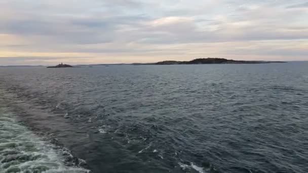 Vista della riva e dell'oceano dalla poppa della nave.Vista delle onde che seguono la nave in tempo soleggiato. I gabbiani volano dietro la nave . — Video Stock