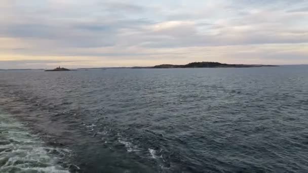 Vue du rivage et de l'océan depuis la poupe du navire.Vue des vagues suivant le navire par temps ensoleillé. Les mouettes volent derrière le navire . — Video