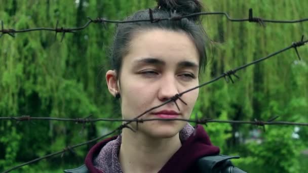 Gyönyörű Fiatal Lány Szomorú Arccal Szögesdrót Mögött Áll Égre Néz — Stock videók