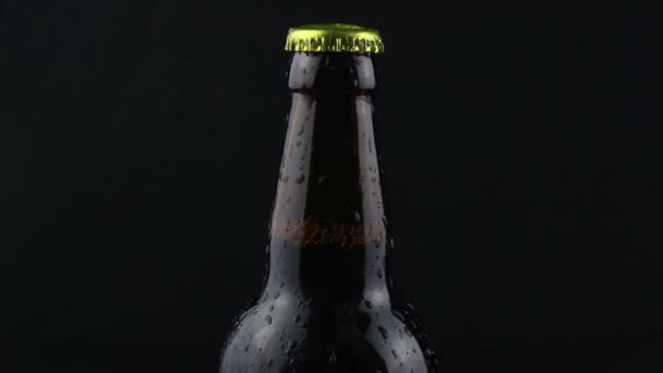 在黑暗的背景下 一滴一滴的冷凝水从啤酒瓶里流了下来 一瓶混浊的啤酒 水从一瓶深色啤酒里流下来 — 图库视频影像