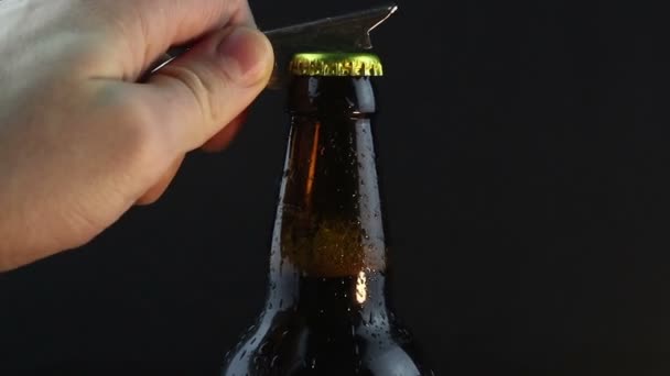 酒保打开了一瓶混浊的黑啤酒 一个年轻人的手打开了一瓶冰冷的黑啤酒 靠近酒保的手打开一瓶啤酒 — 图库视频影像