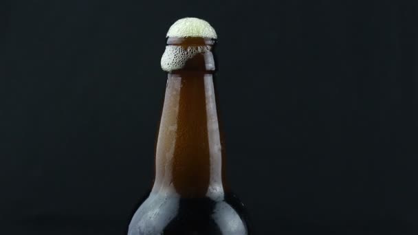 啤酒泡沫从迷蒙的啤酒瓶里流下来 啤酒泡沫从一瓶深色啤酒里流下来 — 图库视频影像