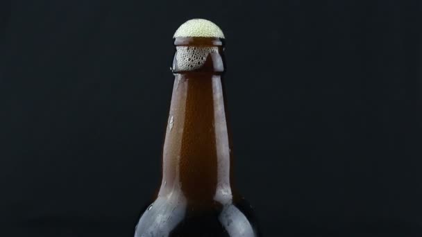 啤酒泡沫从迷蒙的啤酒瓶里流下来 啤酒泡沫从一瓶深色啤酒里流下来 — 图库视频影像
