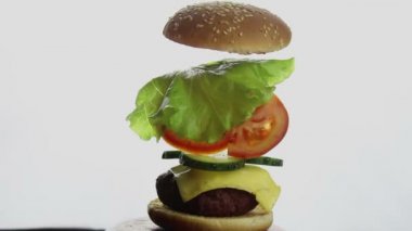 Hamburgerin seçmen kısımları. Sığır pirzolası, taze sebze ve krem peynirli büyük sulu burger. Fast food, yüksek kalorili yemek..