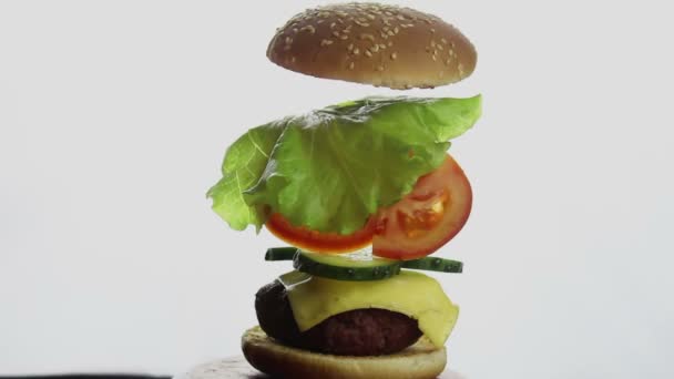 Složené části burgeru. Velký šťavnatý burger s hovězím kotletem, čerstvou zeleninou a smetanovým sýrem. Fast food, high-calorie food.