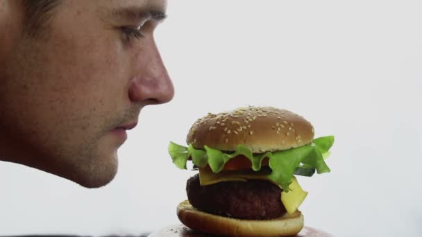 Young Handsome Guy Sniffs Bites Big Juicy Burger Great Pleasure — Stock Video