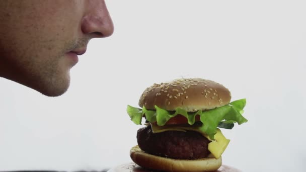 Młody Przystojniak Wącha Potem Wielką Przyjemnością Gryzie Wielkiego Soczystego Burgera — Wideo stockowe