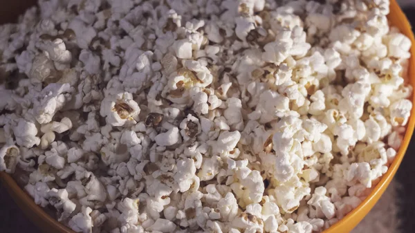 In einer orangefarbenen Schüssel liegt frisches, heißes Popcorn. Kino Popcorn Hintergrund. — Stockfoto