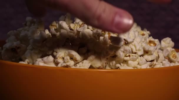 Ein Mann Greift Sich Popcorn Aus Einem Eimer Während Fernsehen — Stockvideo