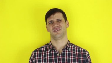 Komik, yakışıklı bir adam ellerini alaycı bir şekilde çırpıyor. Genç bir adamın portresi, olumsuz bir şekilde başını sallıyor ve alaycı bir şekilde alkışlıyor. Sarı arka planda bir portre..