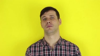 Komik, yakışıklı bir adam ellerini alaycı bir şekilde çırpıyor. Genç bir adamın portresi, olumsuz bir şekilde başını sallıyor ve alaycı bir şekilde alkışlıyor. Sarı arka planda bir portre..