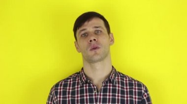 Komik, yakışıklı bir adam ellerini alaycı bir şekilde çırpıyor. Genç bir adamın portresi, olumsuz bir şekilde başını sallıyor ve alaycı bir şekilde alkışlıyor. Sarı arka planda bir portre..