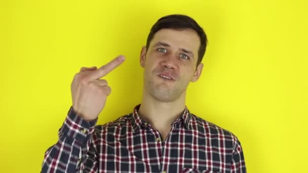 Un mec drôle et beau montre des gestes de main indécents. Portrait d'un jeune homme, il exprime son dégoût et montre des gestes de main indécents . — Video