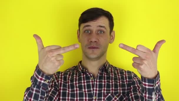 A funny, handsome guy shows indecent hand gestures. Portrait of a young guy, he expresses disgust and shows indecent hand gestures. — Stock Video